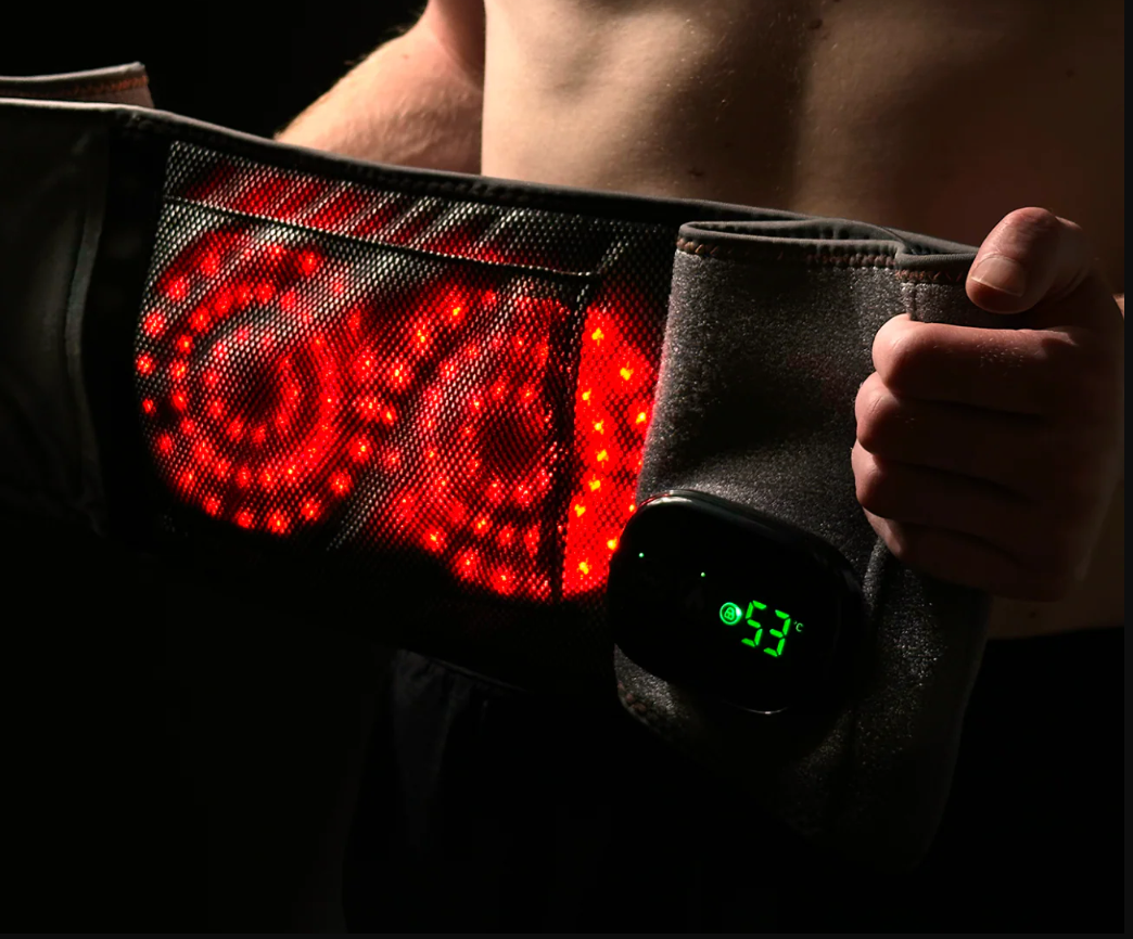 Foto von einer Person die den Infrarot Heizgurt GesundHeat am Ruecken traegt mit leuchtenden roten LED Lichtern und digitaler Temperaturanzeige 53 Grad